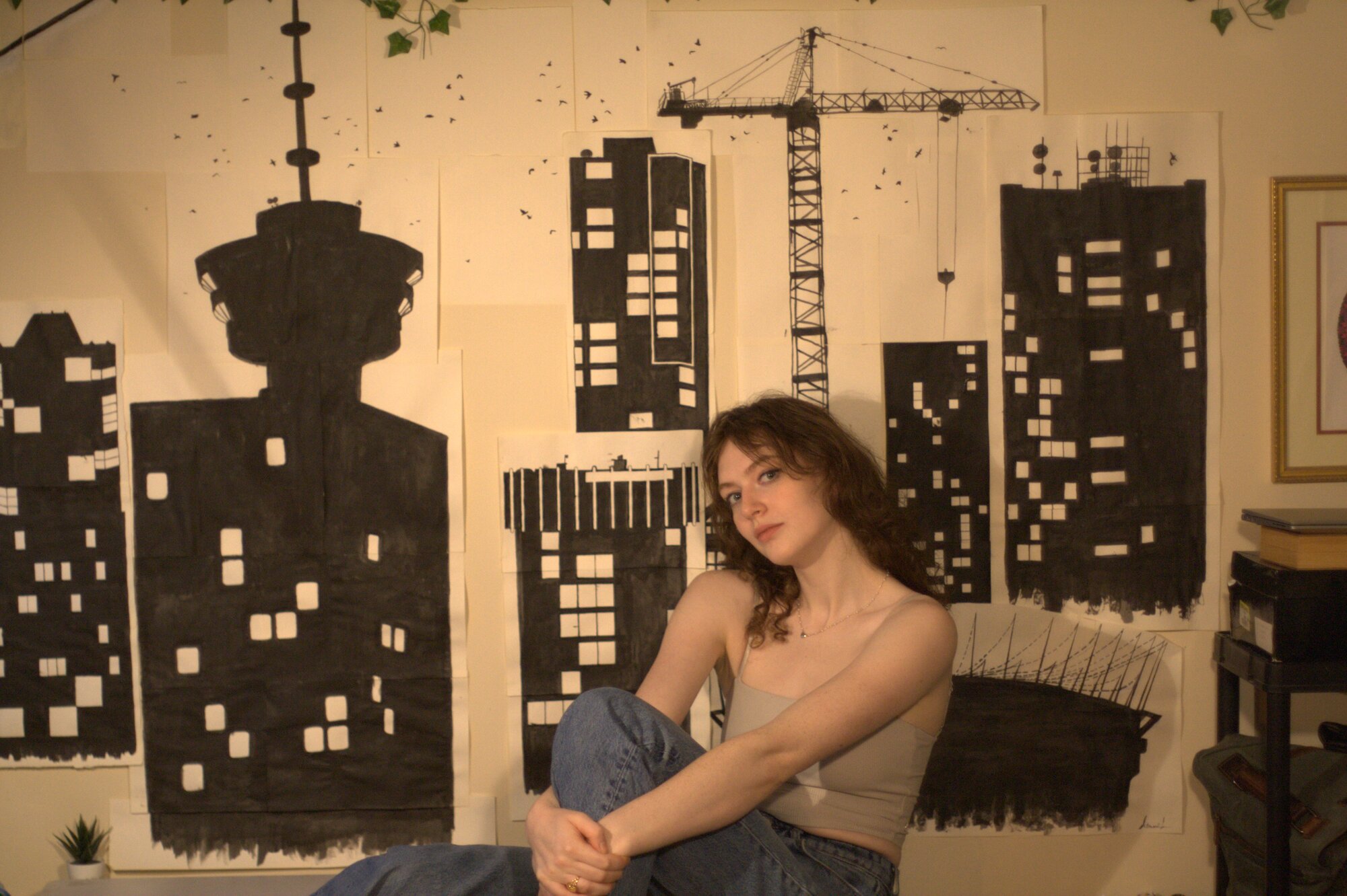 Amanda Ruby in front of her ink cityscape paintings
